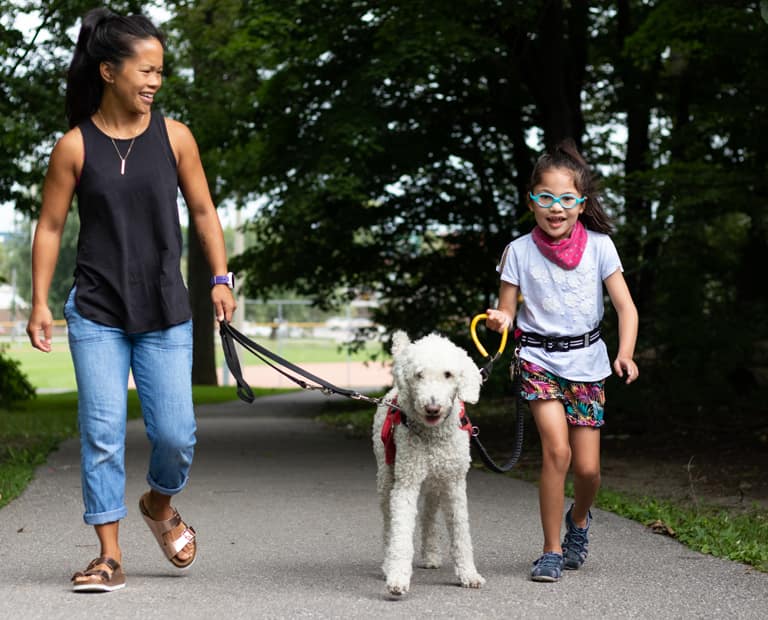 Mère avec enfant attaché à son chien d'assistance à l'autisme