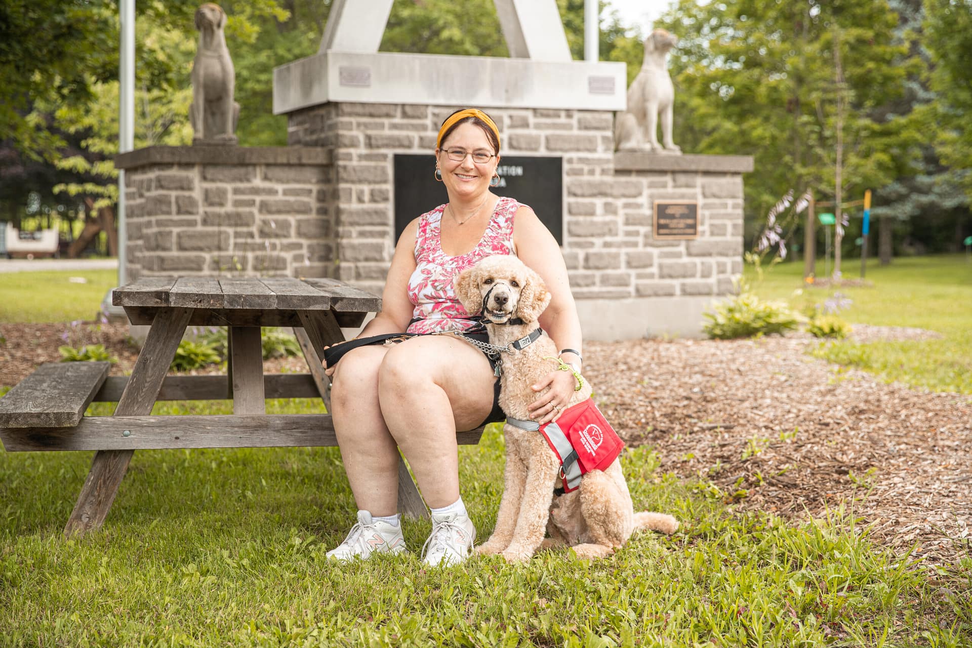 Woman sits next to standard poodle